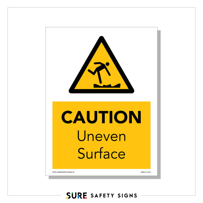 A caution sign with a yellow background depicts a figure tripping over an uneven surface. Text reads CAUTION Uneven Surface, ensuring safety in every step. Proudly branded with Sure Safety Signs, Ireland at the bottom, it highlights commitment to safeguarding public spaces.