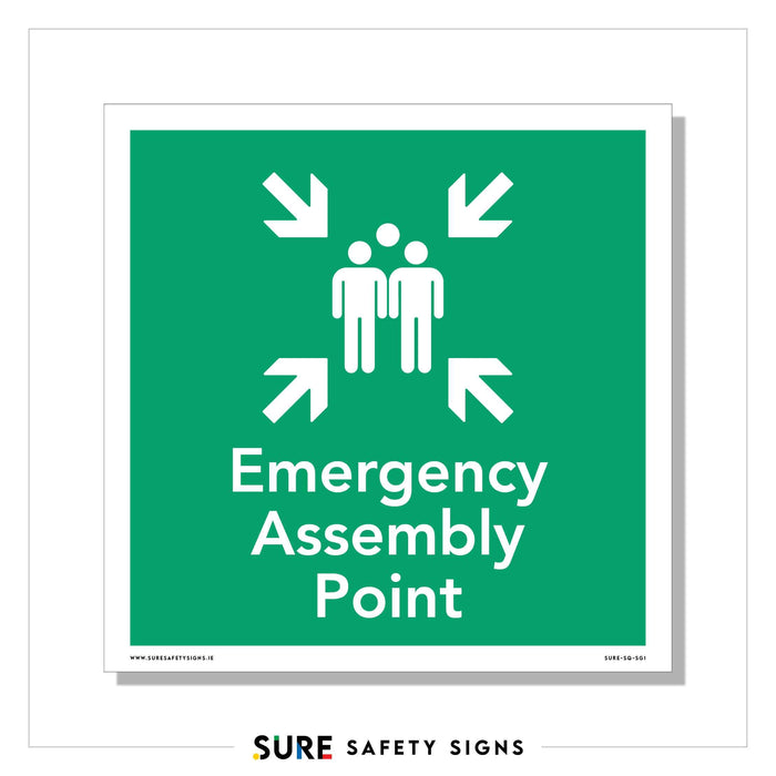 A green safety sign with white text reads Emergency Assembly Point, featuring two stylized person icons surrounded by four inward-pointing arrows. Branded SURE SAFETY SIGNS, its a common sight in Ireland, ensuring everyone knows where to gather in emergencies.