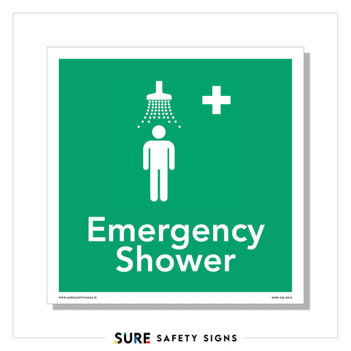 Green safety sign with a white figure under a showerhead, water streams depicted above. A white cross is on the upper right. Text reads Emergency Shower below the illustration, ensuring clear and visible signage in urgent situations.