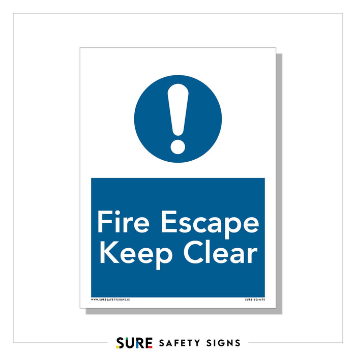 A safety sign marked by a blue circle with an exclamation mark at the top, commonly found in Ireland. Below, in white text on a blue background, it instructs: Fire Escape Keep Clear. A white border frames the sign, emphasizing its importance.