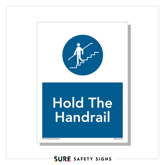 Safety sign showing a stick figure walking down stairs with a hand on the handrail inside a blue circle. Below, text reads Hold The Handrail in white letters on a blue background. Proudly produced in Ireland by SURE SAFETY SIGNS at the bottom.