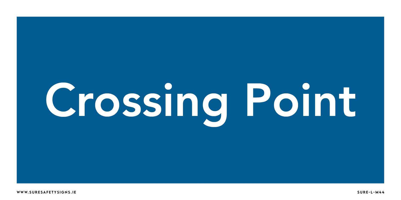 A blue rectangular safety sign with white text reads Crossing Point, reminiscent of those seen throughout Ireland, guiding pedestrians safely.