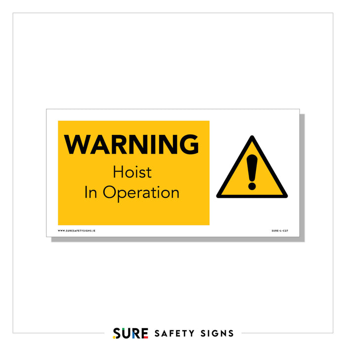 Yellow and white safety sign featuring bold text: WARNING Hoist In Operation. This crucial element of safety communication includes a black exclamation mark inside a yellow triangle.