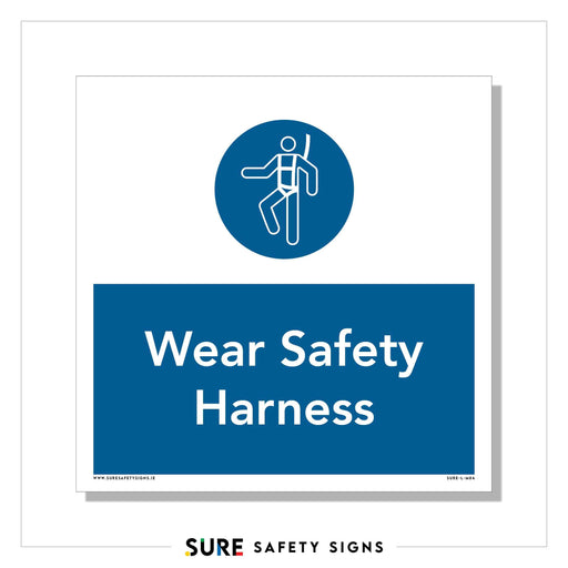 A PPE sign with a blue circle displays a white stick figure sporting a harness. Below, the rectangular blue band reads Wear Safety Harness in white. Labeled SURE SAFETY SIGNS, it emphasizes height safety protection for all.