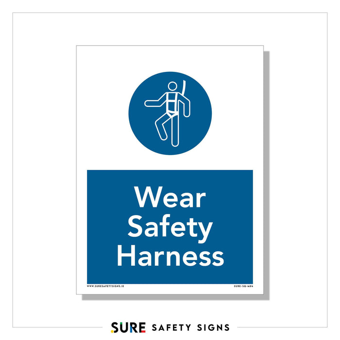 A PPE sign with a blue background and white text reading Wear Safety Harness features an icon of a person wearing a harness. Emphasizing height safety protection, the bottom reads Sure Safety Signs.